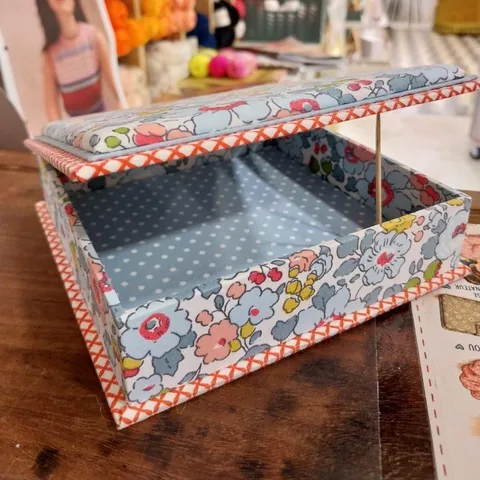Boîte en cartonnage à charnière, habillée de tissu fleuri, couvercle molletonné ouvert