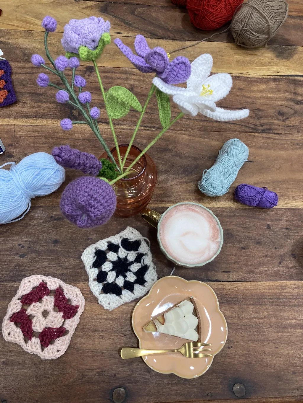 Granny squares au crochet, fleurs crochetées et boissons sur une table en bois