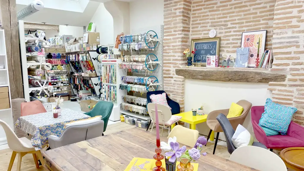 L’intérieur de la mercerie Moha : présentoir de rubans et biais, rayons de laines et tables d’atelier