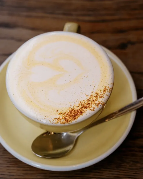 Le Pumpkin spice latte, servi dans une tasse jaune saupoudrée d’épices au café Moha